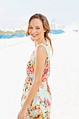 A young woman on a beach wearing a summer dress