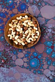 A mixture of nuts (cashews, walnuts, hazelnuts) on a wooden plate