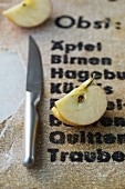 An apple quarter next to a knife