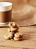 A stack of oat and raisin biscuits in front of a cup of coffee