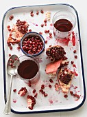 Pomegranate juice with pomegranate seeds and pieces of fruit on a platter