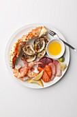 Seafood platter with sauce, wasabi paste and lemon wedges