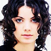 A portrait of a young, dark-haired woman with corkscrew curls