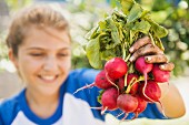 A girl with freshly picked radishes