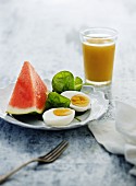 Hartgekochtes Ei mit Wassermelone und Fruchtsaft