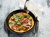 A pancake with serrano ham, spinach and cherry tomatoes