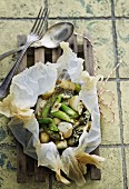 Potatoes, green asparagus and blue cheese in parchment paper