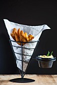 Fried chicken and chips in a paper cone served with mayonnaise