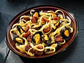 Mussels with Andouille sausage on a bed of linguine