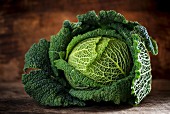 A savoy cabbage on a wooden surface
