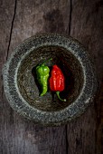 Two fresh chillis in a mortar