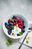 blueberries and raspberries with cream and flaked almonds
