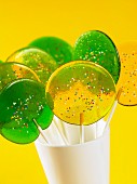 Green and yellow lollipops in a mug