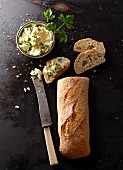Baguette with a knife and cream cheese
