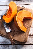 Two pumpkin wedges on a chopping board