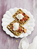 Wholemeal waffles with flacked almonds, strawberries and a scoop of ice cream (seen from above)