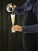Sommelier schenkt Champagner in eine Champagnerglas ein