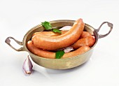 Sausages with onions and bay leaves in a pan