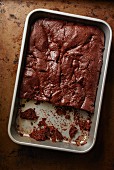 Chocolate cake, sliced, in a baking tin