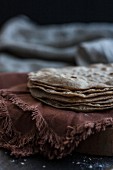 A stack of unleavened bread on a brown cloth