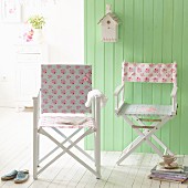 Make-over - two white directors' chairs with new floral covers in front of green wooden wall