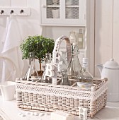 White-painted wicker basket with letter ornaments hanging from handle and crocheted trim on white kitchen table