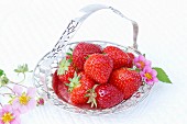 Strawberries and strawberry flowers in a silver dish