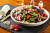 Mixed leaf salad with flaked almonds, strawberries and goat's cheese