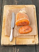 Smoked salmon in a net on a chopping board
