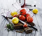 An arrangement of tomatoes and lemons on a wooden surface