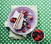 Two slices of chocolate cream tart on a purple plate served with fresh berries