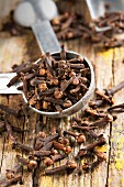 Cloves, some in a measuring spoon