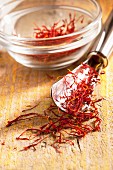 Saffron threads on a spoon and in a glass bowl