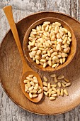Pine nuts in a wooden bowl and on a spoon