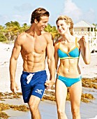 A young couple on a beach wearing swimwear