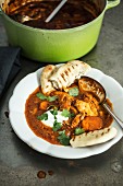 Chicken curry with coriander and unleavened bread (India)