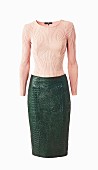A salmon-coloured jumper and green leather, crocodile-look skirt