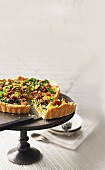 A savoy cabbage tart with tomato and walnut crumbles, sliced