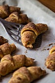 Nut croissants on a baking tray with a spatula
