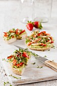Bagel with avocado cream, strawberries and asparagus tips