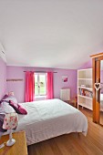Romantic bedroom with lavender-painted walls and lilac and pink textiles