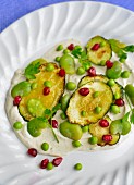 An appetiser of courgettes, peas, broad beans and pomegranate seeds