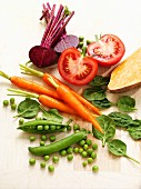 An arrangement of vegetables featuring peas, carrots, spinach, tomatoes and beetroot