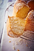 Bundt cake with icing sugar and flaked almonds, sliced
