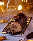 A Christmas chestnut roulade with chocolate glaze and gold leaf