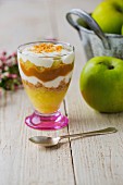 A layered dessert with apple purée, Greek yoghurt, caramel and ginger biscuits