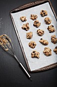 Ungebackene Chocolatechip-Pecannuss-Cookies auf Backpapier