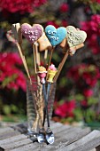 Heart-shaped biscuits on sticks with iced writing