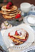 Pancakes with strawberries and icing sugar