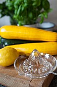 Stillleben mit Zucchini, Zitrone, Basilikum und Zitruspresse
